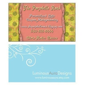 May include: A pink business card with gold glitter accents. The text on the card reads "The Portobello Read", "Personalized Gifts", "Custom Monogramming", "www.theportobelloread.blogspot.com", "540-818-6444", and "Chris-Robin Dawes". A blue business card with white swirls in the top left corner. The text on the card reads "Luminous Aura Designs" and "www.luminousaura.etsy.com".