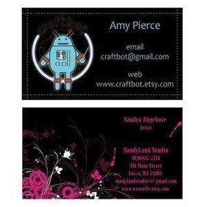 May include: Two business cards, one with a black background and a cartoon robot logo with the text "craftbot" and contact information for Amy Pierce, and the other with a black background and a floral design with contact information for Sandra Engebose, Artist, Sandy Land Studio.