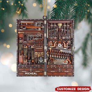 May include: A wooden ornament shaped like a tool chest, filled with various carpentry tools. The ornament has a dark brown finish with a gold string for hanging. The name "MICHEAL" is printed on the front. The words "CUSTOMIZE DESIGN" are printed at the bottom.