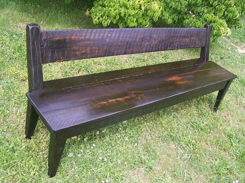 May include: A dark brown wooden bench with a simple design. The bench has a back and is made of reclaimed wood.