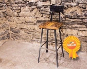 May include: A rustic bar stool with a square wooden seat and a black metal frame. The backrest is also black metal. The stool is set against a stone wall. The seat is approximately 12 inches by 12 inches.