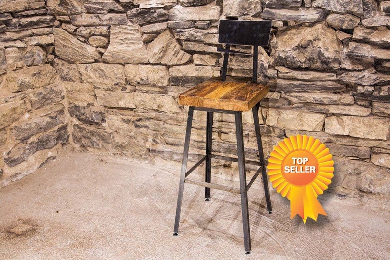Bar stool with walnut wooden top and back close to a massive brick wall