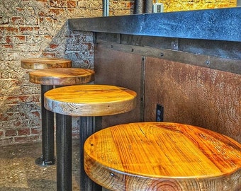 May include: Four wooden bar stools with black metal bases. The stools have a rustic, reclaimed wood look and are arranged in a row.