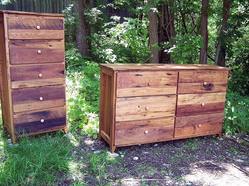 May include: Two wooden chests of drawers with multiple drawers and simple knob pulls. The chests are made of reclaimed wood with a rustic finish.