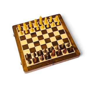 Könnte beinhalten: Ein Schachspiel aus Holz mit einem dunkelbraunen und hellbraunen Schachbrett. Die Schachfiguren sind hellbraun und dunkelbraun. Das Set ist rechteckig und scheint eine faltbare Ausführung zu sein.