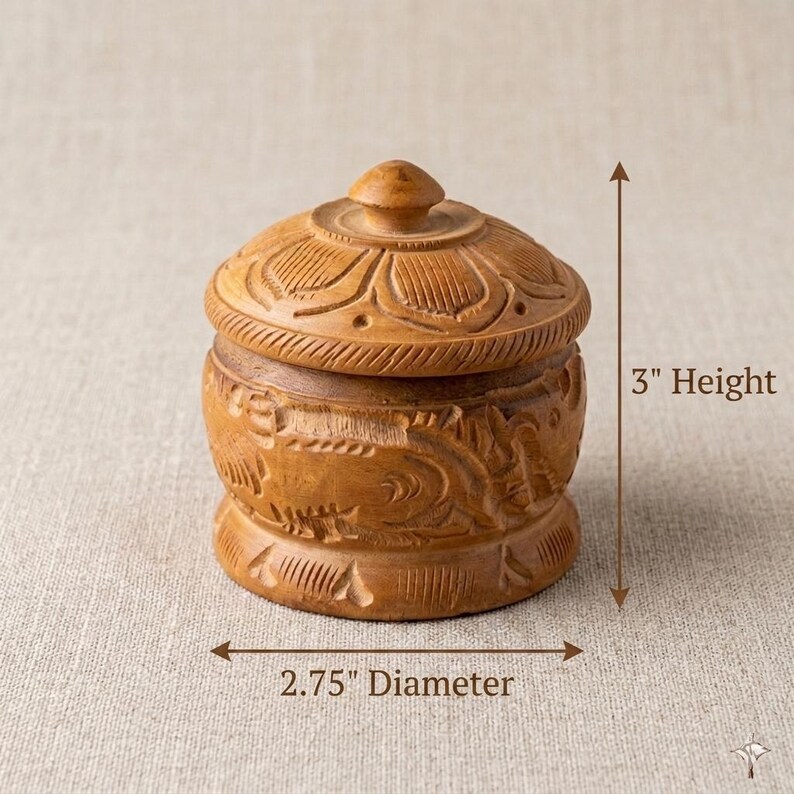 May include: A wooden, lidded container with intricate carvings. The container is 3 inches tall and 2.75 inches in diameter. The lid and body feature floral and swirling patterns. The wood has a warm, natural tone.