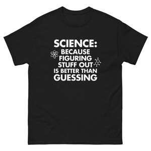 May include: Black t-shirt with white text that reads "SCIENCE: BECAUSE FIGURING STUFF OUT IS BETTER THAN GUESSING." The text is accompanied by atom and molecule graphics. The shirt is a short-sleeved, crew neck style.