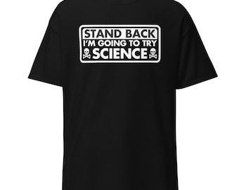 以下が含まれることがあります： 白の長方形のグラフィックが付いた黒いTシャツ。グラフィックには、スカルとクロスボーンのシンボルとともに「STAND BACK I'M GOING TO TRY SCIENCE」と書かれています。シャツは柔らかい素材で作られています。
