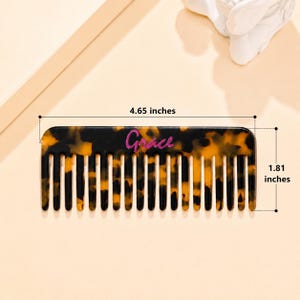 May include: A rectangular hair comb with a brown and black tortoiseshell pattern. The word Grace is printed in pink script on the center of the comb. The comb measures 4.65 inches in length and 1.81 inches in height as indicated by the text.