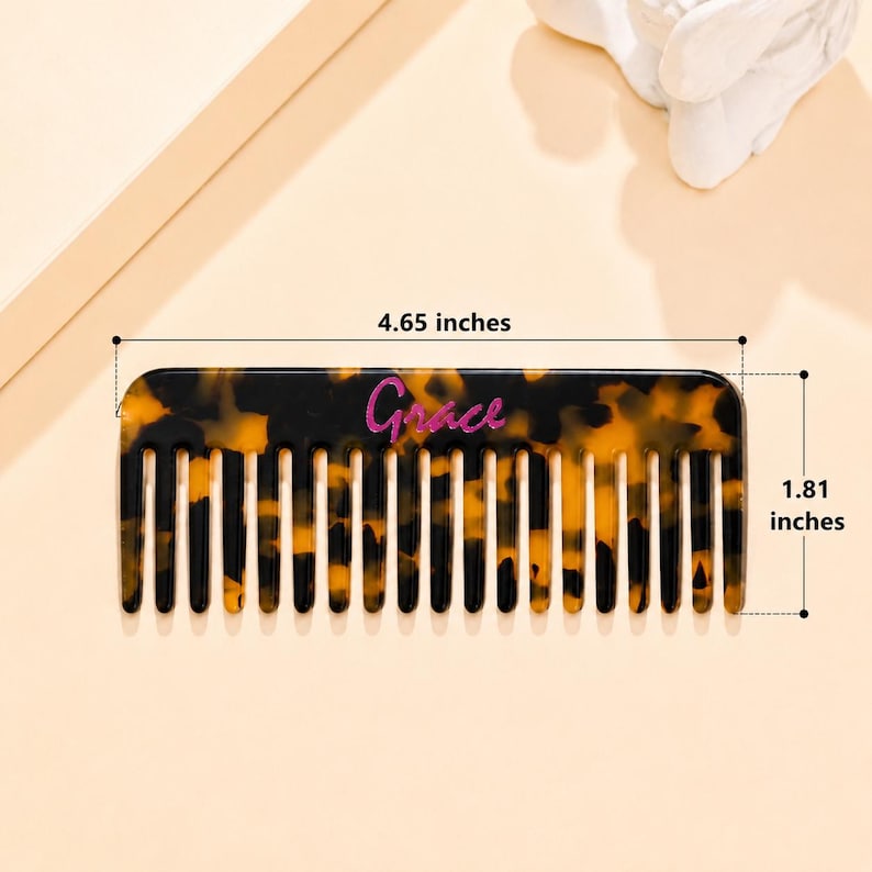 May include: A rectangular hair comb with a brown and black tortoiseshell pattern. The word Grace is printed in pink script on the center of the comb. The comb measures 4.65 inches in length and 1.81 inches in height as indicated by the text.