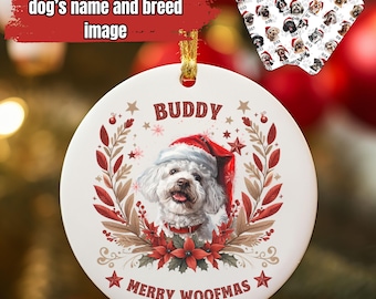 May include: A white ceramic Christmas ornament featuring a dog wearing a Santa hat, the name "Buddy", and the phrase "Merry Woofmas". The ornament is decorated with red and brown floral elements and stars. The text "Make it yours - add your dog's name and breed image" is also visible.