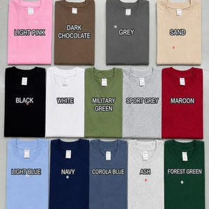 May include: A T-shirt color chart displaying fourteen folded crew neck shirts in various colors including light pink, dark chocolate, grey, sand, black, white, military green, sport grey, maroon, light blue, navy, corola blue, ash, and forest green.