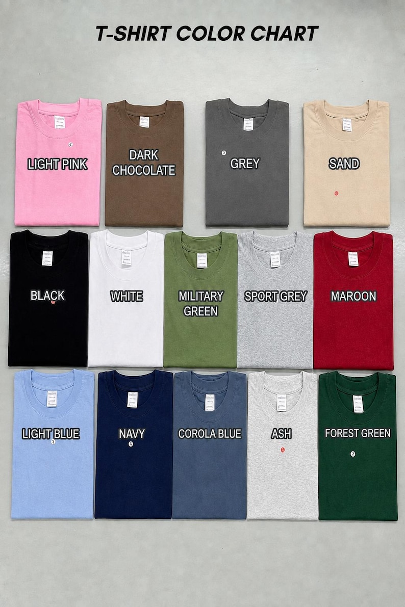 May include: A T-shirt color chart displaying fourteen folded crew neck shirts in various colors including light pink, dark chocolate, grey, sand, black, white, military green, sport grey, maroon, light blue, navy, corola blue, ash, and forest green.