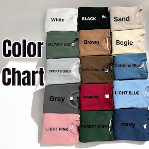 May include: A colour chart showing folded sweatshirts in a range of colours: white, black, sand, military green, brown, beige, sports grey, dark chocolate, grey, maroon, light pink, forest green, navy, light blue, and Carolina blue. The text "Color Chart" is also visible.