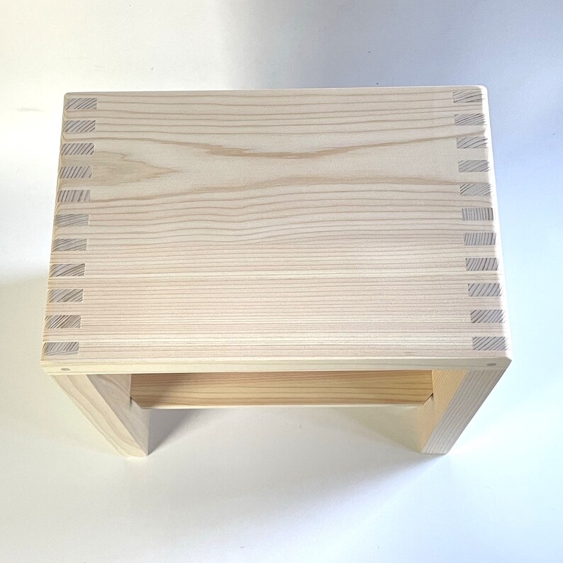 Minimalist Japanese hinoki wood bath stool with a slatted shelf, crafted for durability and traditional spa-style elegance.
