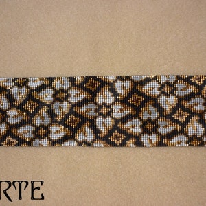 May include: A black, white, and gold beaded bracelet with a geometric pattern. The bracelet is made with small beads and has a clasp closure.