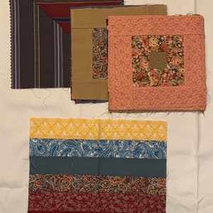 May include: A collection of fabric squares in various patterns and colors. Includes squares with stripes, floral prints, and solid colors. The fabrics are arranged on a white surface, showcasing the different designs and textures.