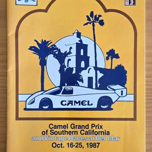 May include: A vintage program cover for the Camel Grand Prix of Southern California and Vintage Races at Del Mar, October 16-25, 1987. The design features a white race car with the word "CAMEL" and a number 1, set against a yellow background with palm trees and a mission-style building.