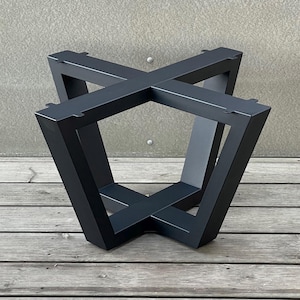 Op de afbeelding: Zwarte metalen tafelpoot met een vierkant ontwerp. De poot is gemaakt van vier metalen delen die in het midden met elkaar zijn verbonden om een vierkant te vormen. De poot is stevig en zou een geweldige aanvulling zijn op elke tafel.