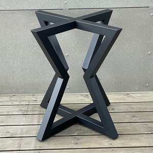 May include: Black metal table base with a geometric, starburst design. The base is made of thick, sturdy metal and has a black finish.