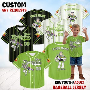 Op de afbeelding: Honkbalshirts in zwart-groene krijtstrepen en effen groen, met het personage Buzz Lightyear en de tekst "Buzz Lightyear 00". De shirts zijn aanpasbaar met de tekst "YOUR NAME". De afbeelding bevat ook een kind dat een groen shirt draagt.