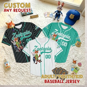 Puede incluir: Tres camisetas de b&eacute;isbol con la palabra "Zootopia" y el n&uacute;mero "00" impresos. Las camisetas son negras, blancas y verde azulado con rayas finas. La imagen tambi&eacute;n incluye una gorra de polic&iacute;a azul, un conejito de peluche y otros art&iacute;culos tem&aacute;ticos de Zootopia.
