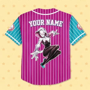 Puede incluir: Una camiseta de b&eacute;isbol con cuerpo magenta y rayas verticales blancas. Las mangas son turquesas con rayas blancas. La camiseta presenta el texto "YOUR NAME" en la espalda y un gr&aacute;fico de un superh&eacute;roe.
