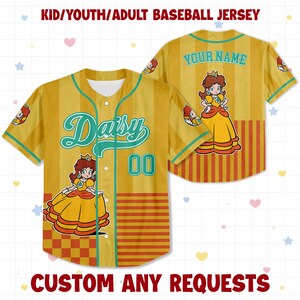 May include: A yellow baseball jersey featuring vertical stripes, a button-down front, and the name Daisy in teal script. The front displays the number 00 and a graphic of Princess Daisy. The back includes the text YOUR NAME and a Princess Daisy graphic.