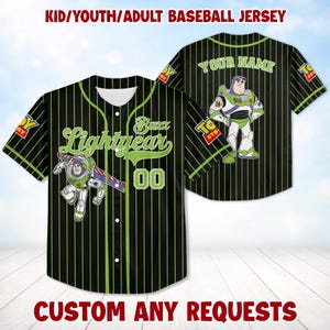 Op de afbeelding: Zwart honkbalshirt met groene krijtstrepen, met Buzz Lightyear-graphics en de tekst "Buzz Lightyear" en "00". De trui heeft de tekst "YOUR NAME" op de achterkant en "TOY STORY" logo's op de mouwen.