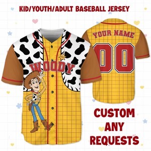 May include: A yellow baseball jersey with a grid pattern, brown sleeves, and a white and black cow-print yoke. The jersey features a cartoon image of Woody, the word "WOODY", and the text "KID/YOUTH/ADULT BASEBALL JERSEY". The back has the text "YOUR NAME" and the number "00".