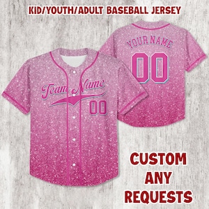 May include: Pink baseball jersey with a glitter effect. The front features the text "Team Name" and the number "00". The back displays "Your Name" and the number "00". The jersey is designed for kids, youth, and adults.