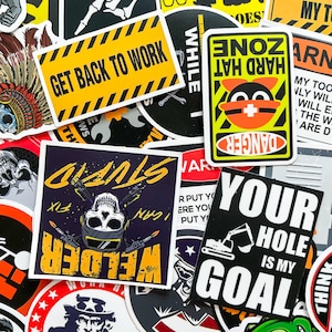 May include: A selection of vibrant stickers with diverse designs and text. One sticker displays "GET BACK TO WORK" in black on a yellow background. Another says "HARD HAT ZONE" with a cartoon character. Other stickers feature skulls and construction equipment.