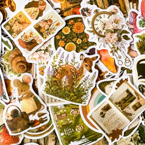 K&ouml;nnte beinhalten: Eine Sammlung bunter Aufkleber mit verschiedenen Designs, die von der Natur inspiriert sind, darunter ein Reh im Wald, eine Schnecke, eine Uhr mit Blumen und ein Pilz. Die Aufkleber sind perfekt, um Tageb&uuml;chern, Planern und anderen Bastelprojekten einen Hauch von Verspieltheit zu verleihen.