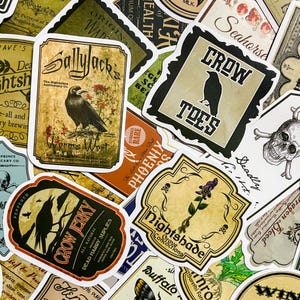 Op de afbeelding: Een verzameling vintage stickers met een griezelig, gotisch thema. De stickers bevatten illustraties van kraaien, schedels en andere macabere afbeeldingen. De tekst op de stickers bevat zinnen als "Crow Toes", "Worm's Wort" en "Deadly Nightshade".