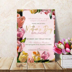 May include: A pink and gold Mother's Day brunch invitation with a floral design featuring pink and yellow tulips. The invitation includes the text "A celebration of love, sacrifice, and grace of motherhood."  "Please join us for a Mother's Day Brunch."  "Saturday, May 17th at 11:00 AM."  "The Anderson Residence."  "025 Springville Drive, Houston, TX 8800."  "RSVP to Olivia at 111-222-3456 by 5th May."