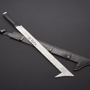 Puede incluir: Una espada plateada con empuñadura negra y funda de cuero. La espada tiene un diseño de hoja angular. La funda es negra con ribetes marrones y cierres de botón. El texto "© Yj.Co" es visible en la hoja.