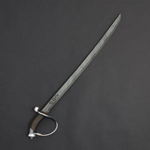 May include: A silver saber with a curved blade and a brown handle. The hilt features a silver guard and a decorative pommel. The text "&copy; Yj.Co" is etched on the blade. The sword is set against a dark gray background.