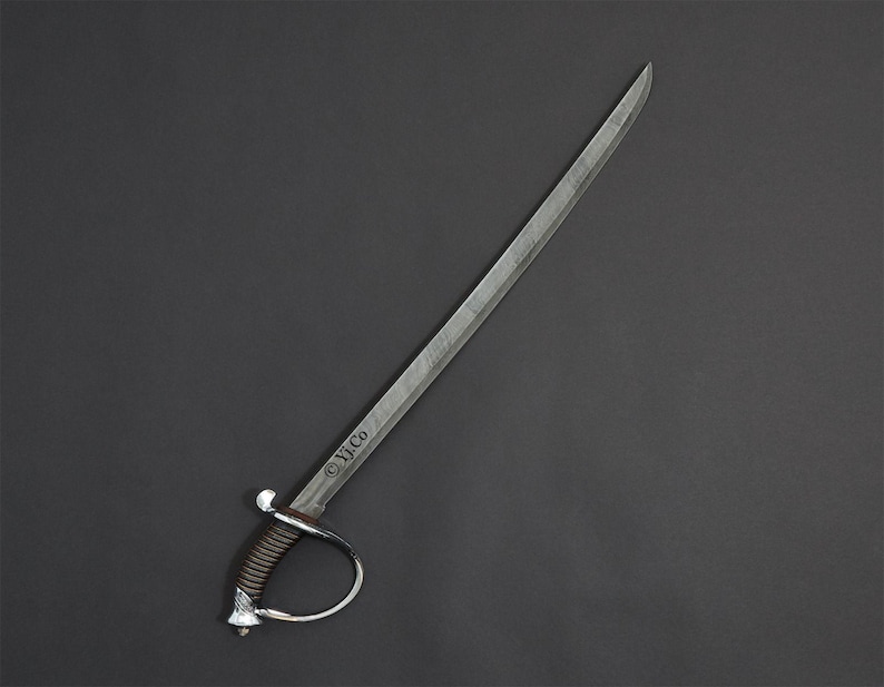 May include: A silver saber with a curved blade and a brown handle. The hilt features a silver guard and a decorative pommel. The text "&copy; Yj.Co" is etched on the blade. The sword is set against a dark gray background.