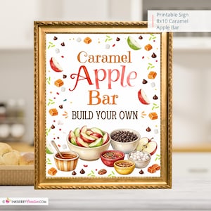 May include: A rectangular gold-framed sign featuring the text Caramel Apple Bar BUILD YOUR OWN. The illustration includes bowls of sliced apples, chocolate chips, caramel, and marshmallows, with scattered sprinkles and apple slices on a white background.