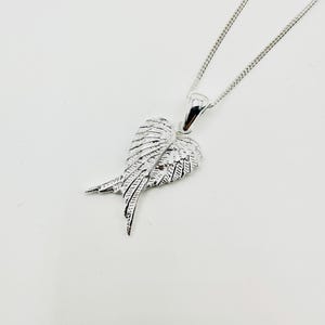 Puede incluir: Collar con colgante plateado con dise&ntilde;o de ala. El colgante, con detalles de plumas, cuelga de una fina cadena. Esta joya es sencilla pero elegante. Un accesorio cl&aacute;sico.