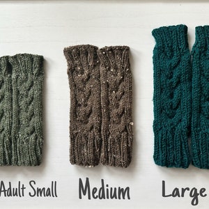 May include: Three pairs of knitted arm warmers in different sizes: teen/adult small, medium, and large. The arm warmers are green, brown, and teal.