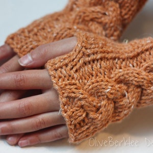 May include: A pair of brown knitted fingerless gloves with a cable knit pattern. The gloves are made with a soft, warm yarn.
