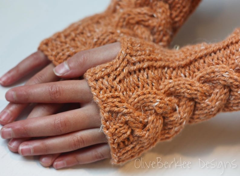 May include: A pair of brown knitted fingerless gloves with a cable knit pattern. The gloves are made with a soft, warm yarn.