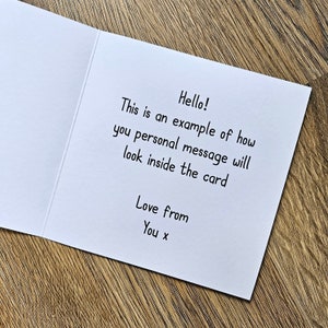 Peut inclure: Une carte blanche avec un message manuscrit qui dit "Hello! This is an example of how you personal message will look inside the card Love from You x".