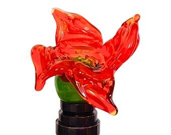 May include: A red glass flower finial with a green center, mounted on a bronze base.