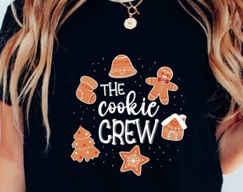 May include: A black t-shirt with a white graphic design featuring gingerbread cookies and the text "The cookie crew".