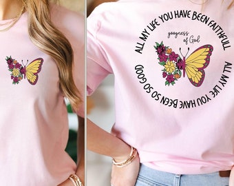 May include: Pink t-shirt with a butterfly and floral design on the front and the text "All my life you have been so so good goodness of God All my life you have been faithful" on the back.