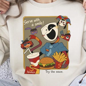 May include: Cream-colored sweatshirt featuring a cartoon illustration of a fast-food restaurant scene. The design includes a smiling character, a burger, fries, and a drink. Text on the design reads "Serve with a smile!" and "Try the sauce."