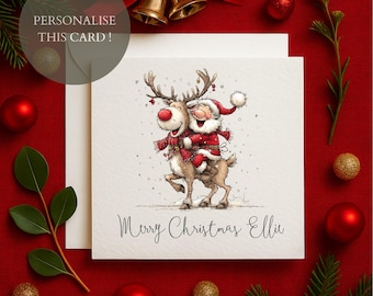 May include: A Christmas card featuring Santa Claus riding a reindeer, both smiling and wearing red and white outfits. The card has the text "Merry Christmas Ellie" and the words "Personalise This Card!" in a circle. The background is red with Christmas ornaments.