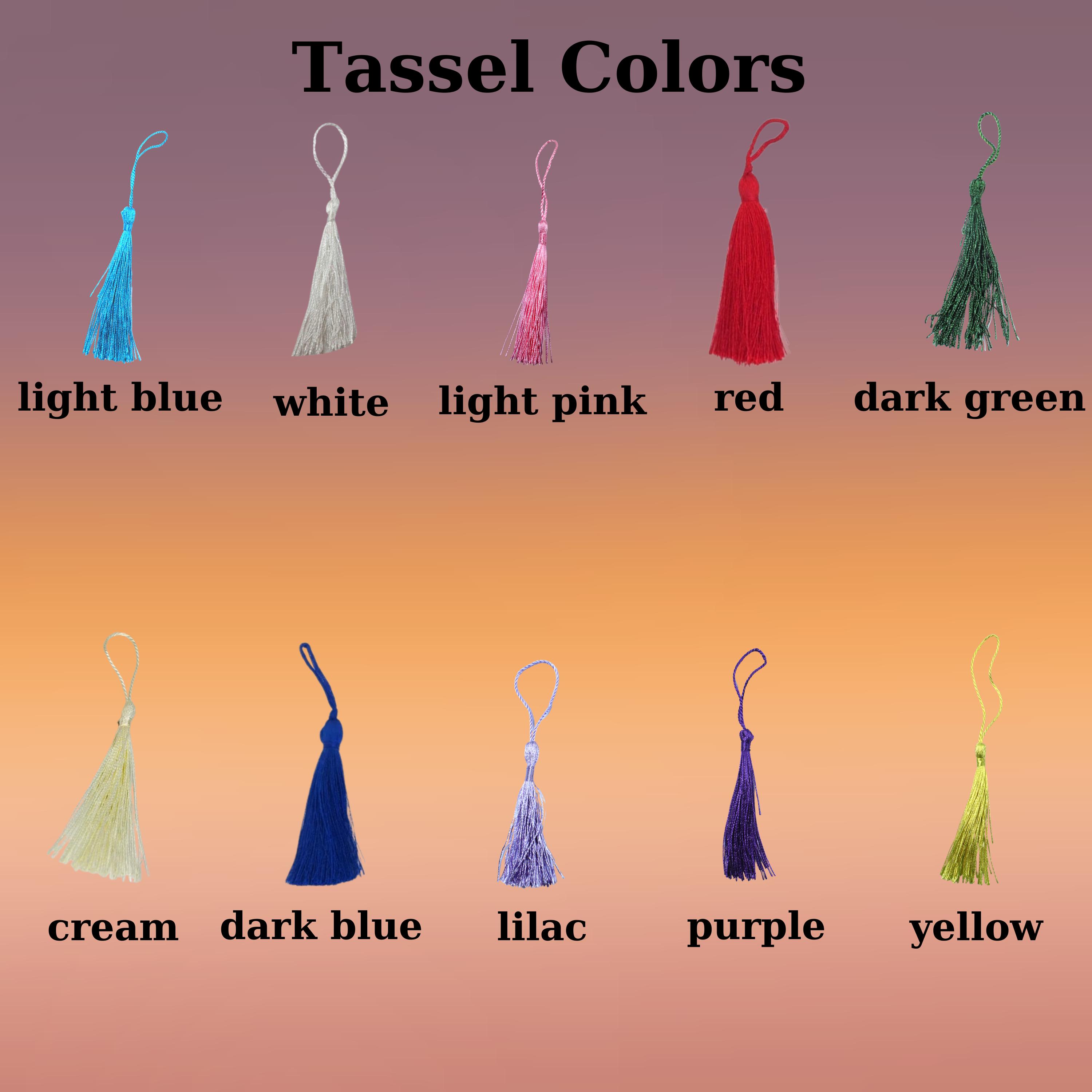 A collection of tassels in various colors. The tassels include light blue, white, light pink, red, dark green, cream, dark blue, lilac, purple, and yellow. Each tassel is displayed with its corresponding color name.